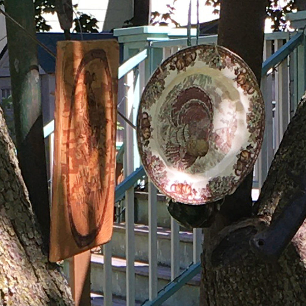 detaili of ceramic plate showing turkey and wood plaque angled so image cannot be made out