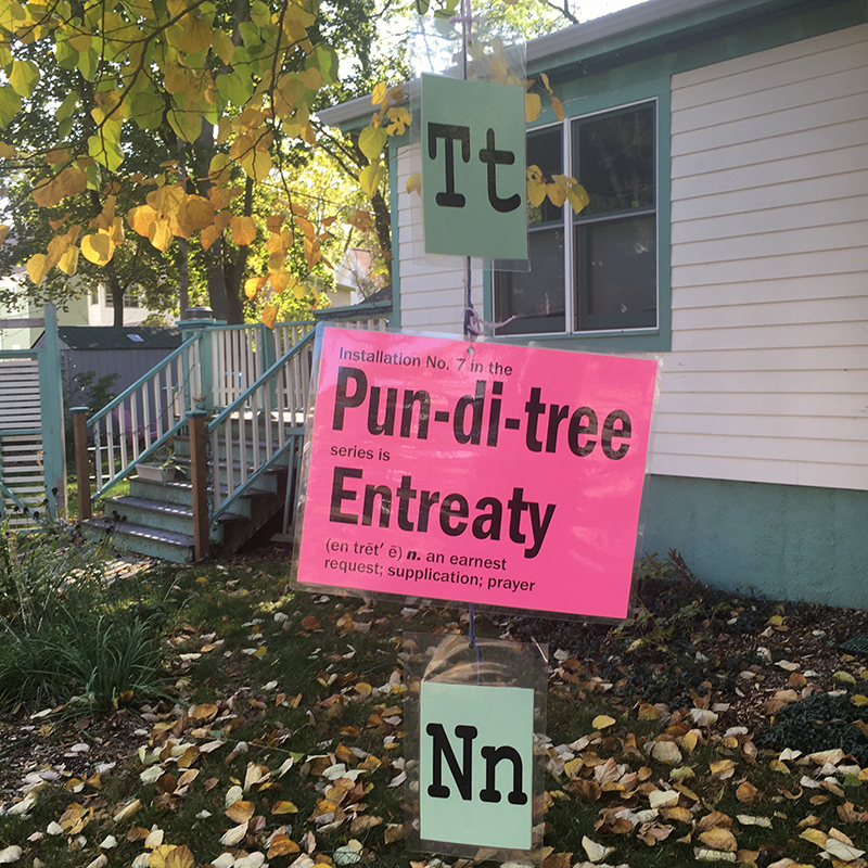 Letters T and N plus sign saying "Pun-di-tree" hanging from tree branch