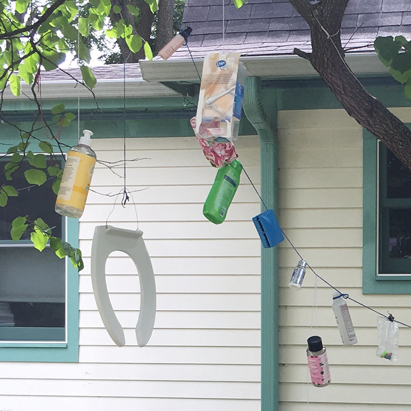 Bottles of shampoo, conditioner, hand lotion, etc.; ear swab container; bag of ear plugs; soap box; ditty bag; and toilet seat hanging from tree branches